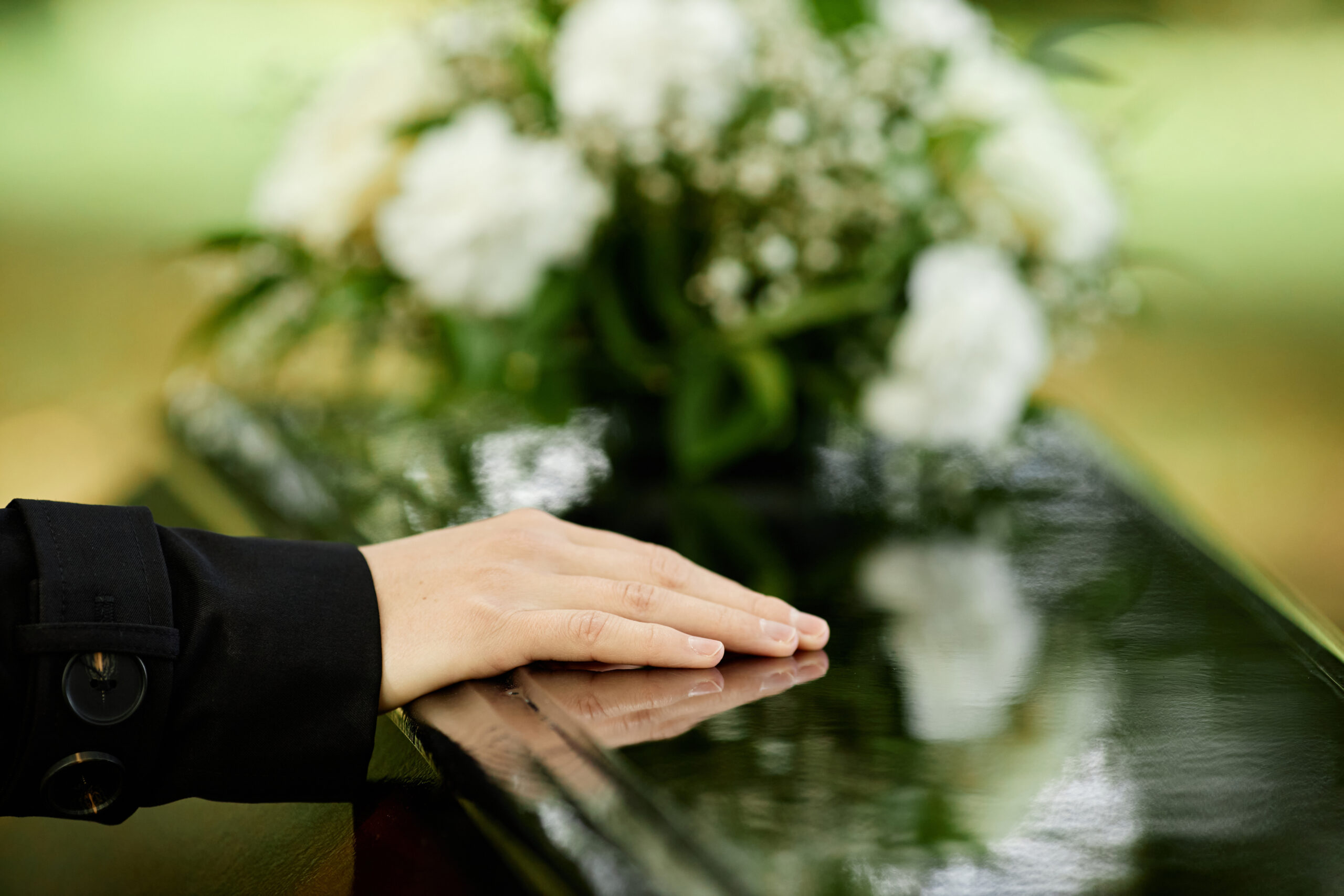 hand resting on coffin